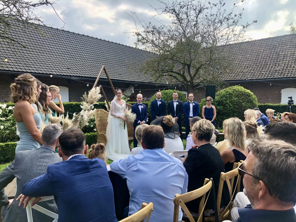 Cérémonie de mariage en plein air avec des mariés, des invités, et une décoration élégante.