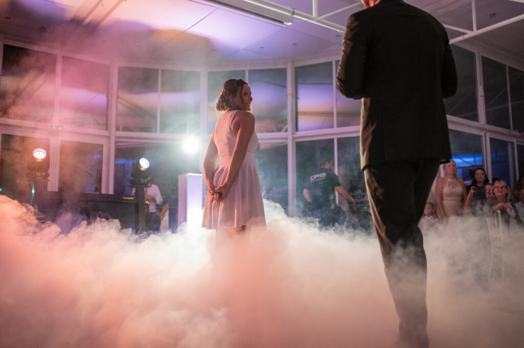 Mariés réalisant un slow romantique entourés de fumée, créant une atmosphère magique et intimiste sur la piste de danse.
